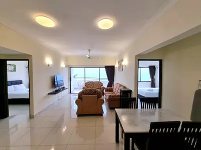 a living room with a couch and a table at Aloka Seaview Apartment in Batu Ferringhi
