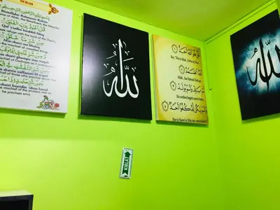 a green wall with signs on the wall at Orchid Haven in Cameron Highlands