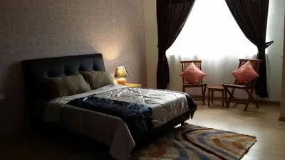 a bedroom with a bed and chairs and a window at 118 Suite in George Town