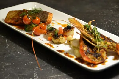 a plate of food with fish and vegetables on a table at Meru Suites at Meru Valley Resort in Ipoh