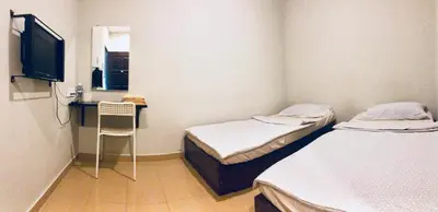 two beds in a room with a desk and a television at Lunas Bliss in Lunas