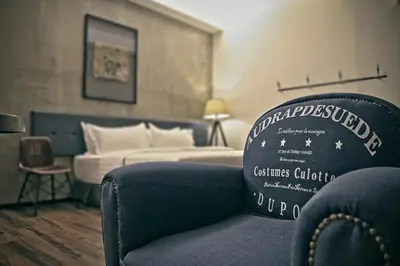 a hotel room with a chair and a bed at Merton Hotel Ipoh in Ipoh
