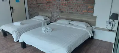 two beds with white sheets in a room at Hotel Nelayan in Pangkor