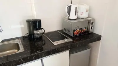 a kitchen counter with a coffee maker and a microwave at Kurau Inn Boutique Farmstay in Kuala Kurau