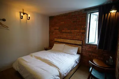 a bed in a room with a brick wall at Brick Box Hotel @ Oldtown Ipoh in Ipoh