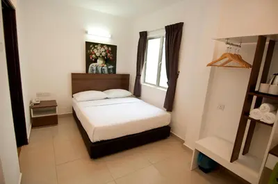 a small bedroom with a bed and a window at Hotel Cheqinn in Ipoh