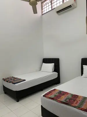 a bedroom with two beds and a window at Taiping Vacation Homestay in Taiping
