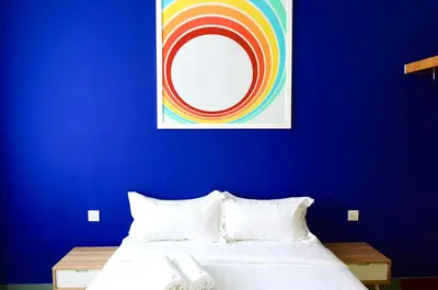 a blue bedroom with a bed and a painting on the wall at Dream & Wander Homestay in Ipoh