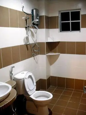 a bathroom with a toilet and a shower at Lacy's Crown Imperial Court Apartment in Cameron Highlands