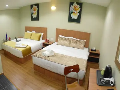 a hotel room with two beds and a telephone at Royale Hotel Batu Gajah in Ipoh