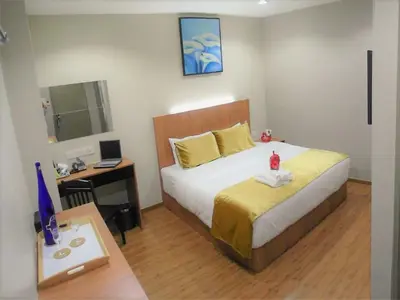 a bedroom with a bed and a desk with a computer at Royale Hotel Batu Gajah in Ipoh