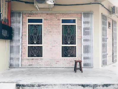 a building with two windows and a wooden stool at Rock Wood Hotel in Sungai Petani