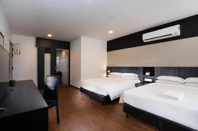 a hotel room with two beds and a desk at Hotel Waterfall in George Town
