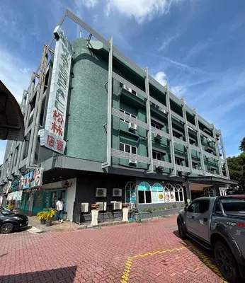 a green building with cars parked in front of it at Hotel Waterfall in George Town
