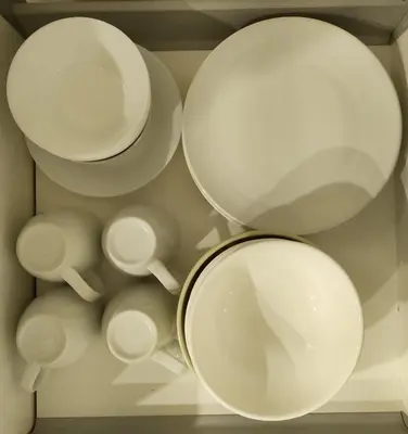 a group of white plates and bowls in a drawer at Penang Studio Suite in Georgetown in George Town