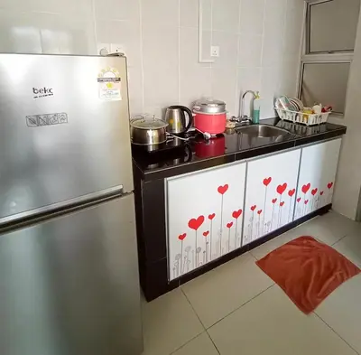 a kitchen with a refrigerator and a sink with hearts painted on it at Cameron's Square Apartment in Cameron Highlands