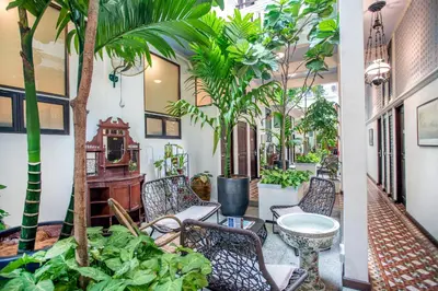 a courtyard with chairs and trees in a building at Areca Hotel Penang in George Town