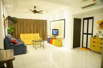 a living room with a couch and a tv at Sri Sayang by Coral Holiday Resort in Batu Ferringhi
