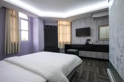a bedroom with a bed and a desk and a television at S Hotel Seberang Jaya in Perai