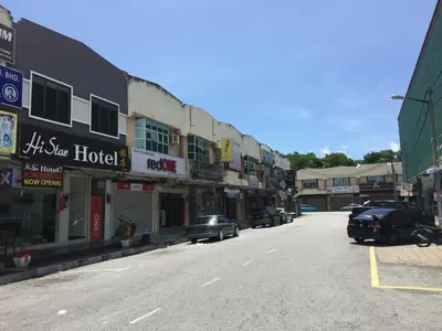 an empty city street with cars parked on the street at Hi Star Hotel in Sitiawan