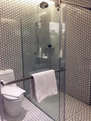 a bathroom with a shower with a toilet and towels at M Roof Hotel & Residences in Ipoh