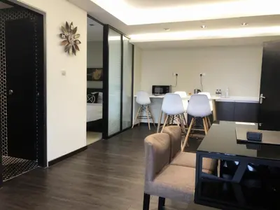 a living room with white chairs and a table at M Roof Hotel & Residences in Ipoh