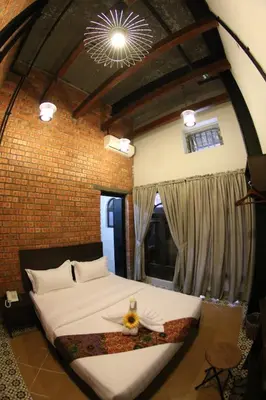 a bedroom with a large bed in a brick wall at JQ Ban Loong Boutique Hotel in Ipoh