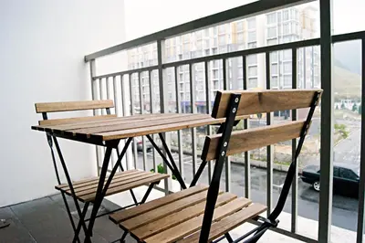 a wooden table and a bench on a balcony at Play Residence at Golden Hills in Cameron Highlands