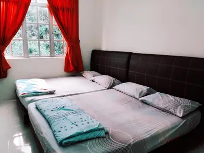 a large bed in a room with red curtains at SA Apartments @ Crown Imperial Court in Cameron Highlands
