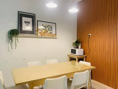 a dining room with a wooden table and white chairs at D'Houzz in Sungai Petani