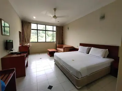 a bedroom with a large white bed and a desk at Wawa's Golf View Inn in Taiping