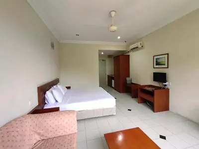 a bedroom with a bed and a desk and a television at Wawa's Golf View Inn in Taiping