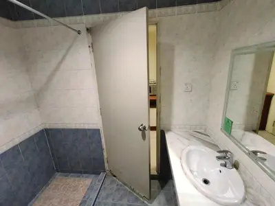 a bathroom with a sink and a toilet and a door at Wawa's Golf View Inn in Taiping