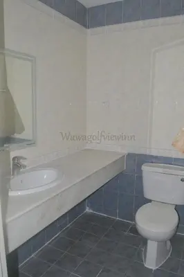 a bathroom with a toilet and a tub and a sink at Wawa's Golf View Inn in Taiping