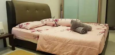a bed with pink sheets and flowers on it at Fahaz Kamunting Taiping in Taiping