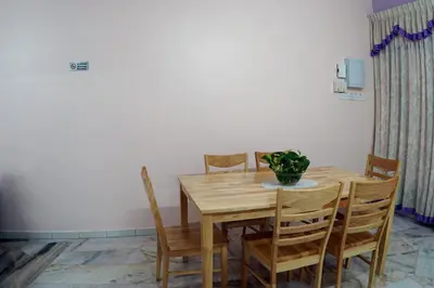 a dining room table with chairs and a vase on it at Taiping Cozy Homestay in Taiping