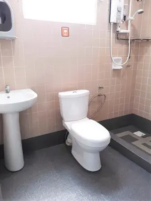 a bathroom with a white toilet and a sink at 5-MINS WALK TO BEACH WITH POOL, Batu Ferringhi in Batu Ferringhi