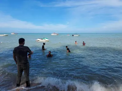 a group of people in the water at the beach at 5-MINS WALK TO BEACH WITH POOL, Batu Ferringhi in Batu Ferringhi