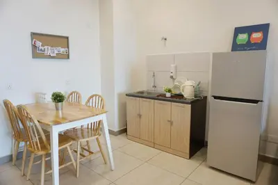 a kitchen with a table and a refrigerator at PM Octagon Ipoh Suites & Apartment 1 in Ipoh