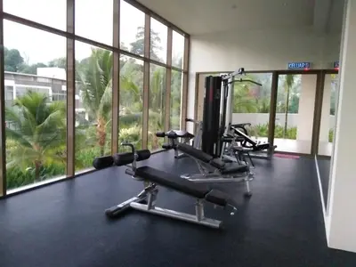 a gym with two tread machines and large windows at By The Sea Duplex Condo in Batu Ferringhi