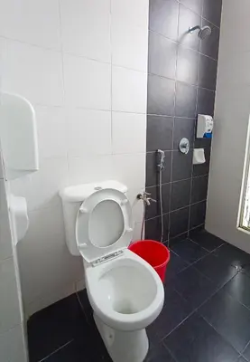 a bathroom with a white toilet and a red bucket at Cameron 2Room Square @Golden Hill in Cameron Highlands