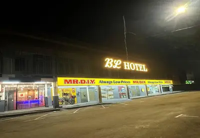 a large building with a motorcycle shop at night at JQ BL Hotel, Ipoh in Ipoh