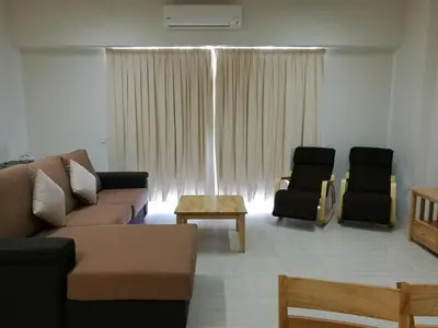 a living room with a couch and two chairs at By The Sea at Batu Ferringhi Penang in Batu Ferringhi