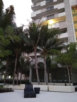 a group of palm trees in front of a building at By The Sea at Batu Ferringhi Penang in Batu Ferringhi