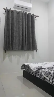 a bedroom with a bed and a curtain on a wall at Gerik The Great RestHouse in Gerik