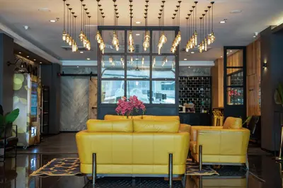 a living room with a yellow couch and a chandelier at Summer Tree Hotel Penang in George Town