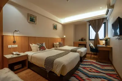 a hotel room with two beds and a television at Summer Tree Hotel Penang in George Town