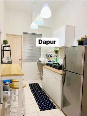 a kitchen with white cabinets and a black refrigerator at Eira Homestay Lost World Of Tambun M uslim only in Ipoh