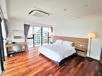 a bedroom with a bed and a desk and a window at Sunrise Gurney in George Town