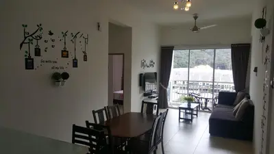 a dining room and living room with a table and chairs at My Home Apartment @ Golden Hills in Cameron Highlands